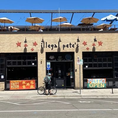 Old Town storefront with the rooftop patio visible above and a Happy Hour banner in the window
