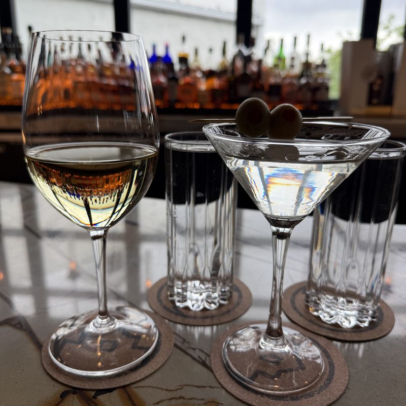 Dirty martini with olives and a wine glass on the upstairs bar